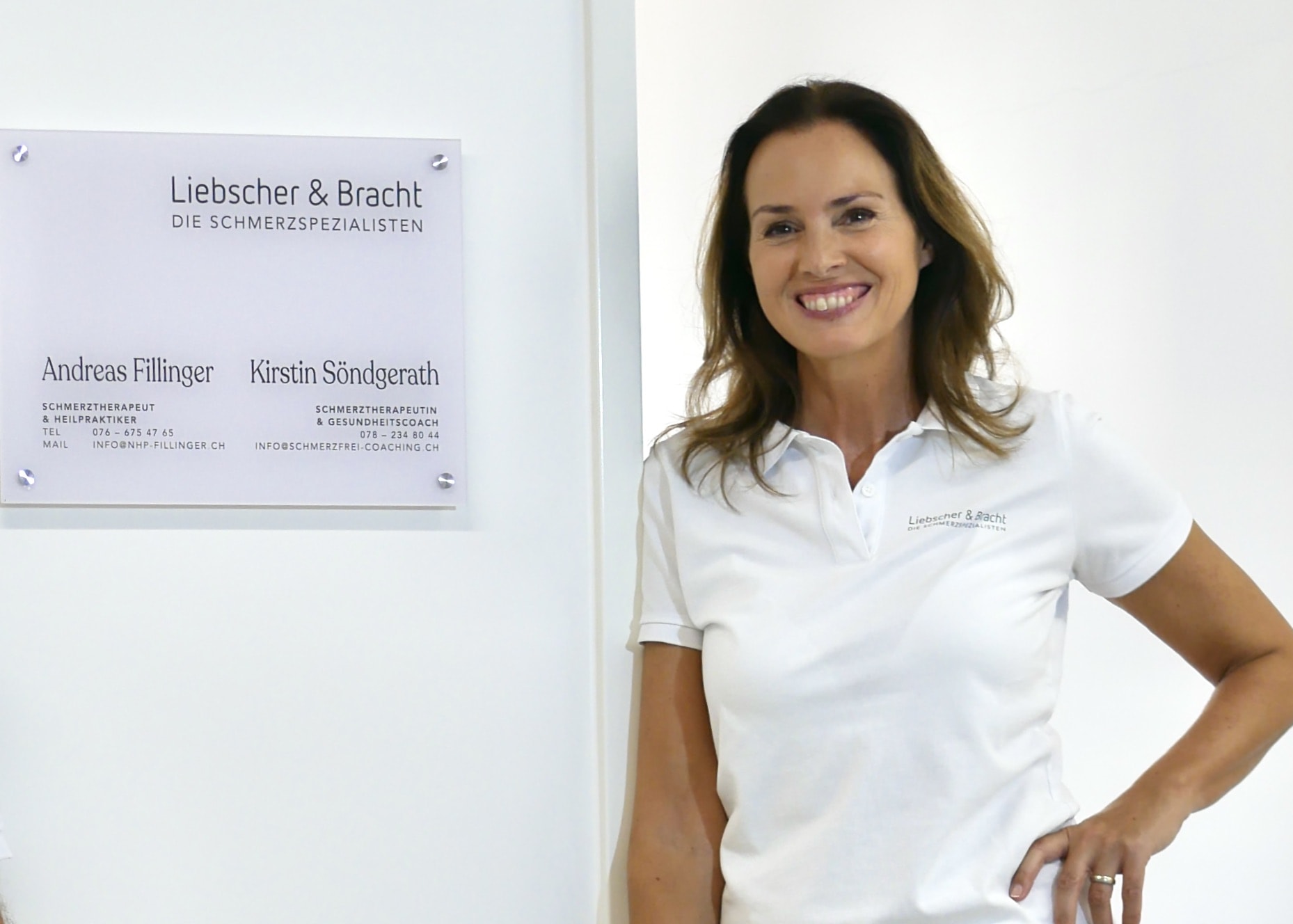 Frau vor Schmerztherapie-Praxis mit Schild, freundlich lächelnde Schmerztherapeutin, professionell und einladend.